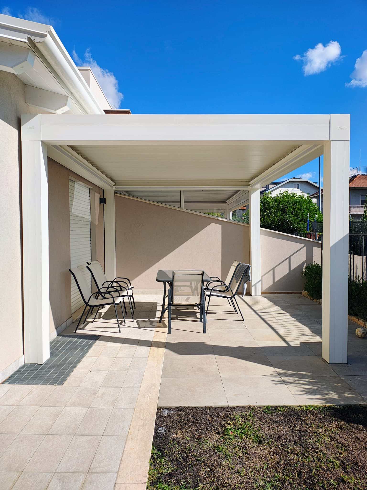 Pergola bioclimatica bianca su un terrazzo sotto il cielo azzurro