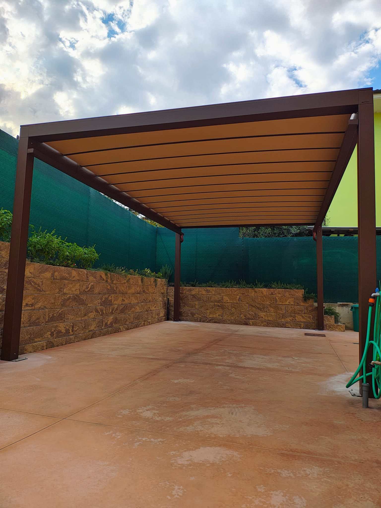 Pergola bioclimatica color corten su un cortile