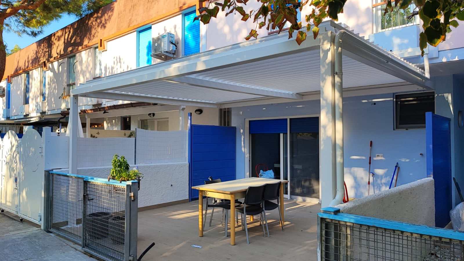 Pergola bioclimatica in cortile vista di lato, con le lamelle orientate