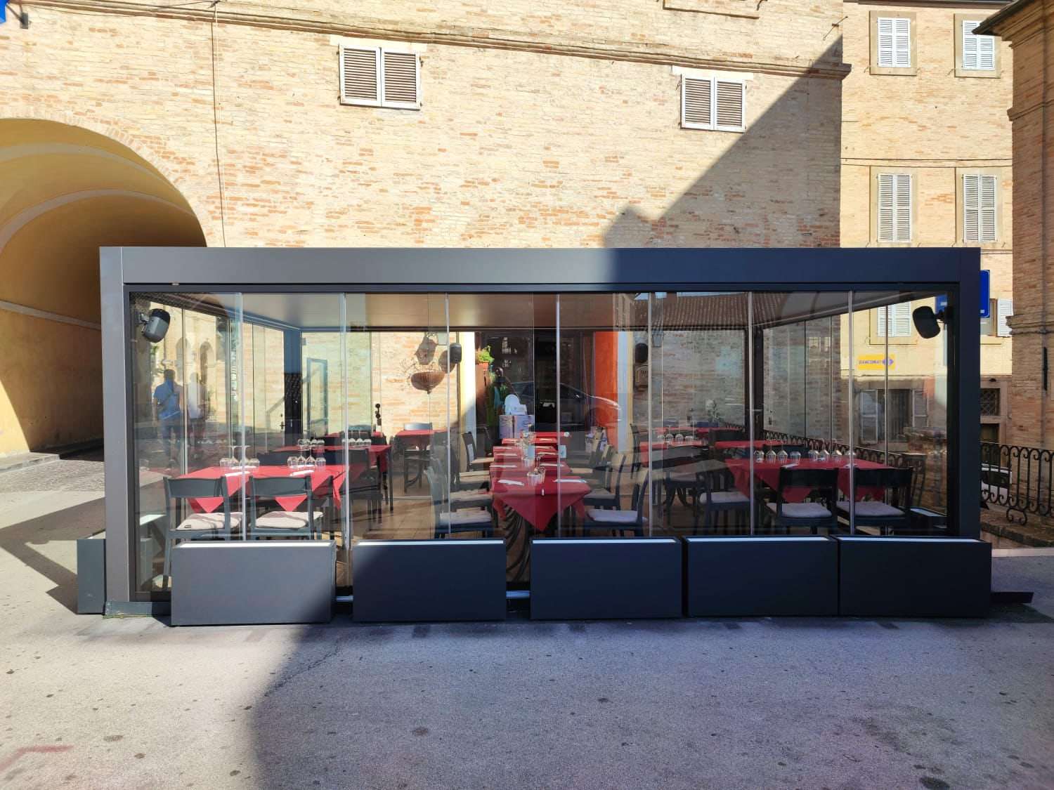 Sala esterna di un ristorante chiusa con pergola bioclimatica e vetrate scorrevoli