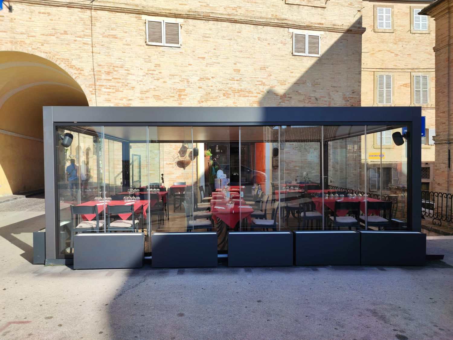 Sala esterna di un ristorante chiusa con pergola bioclimatica e vetrate scorrevoli