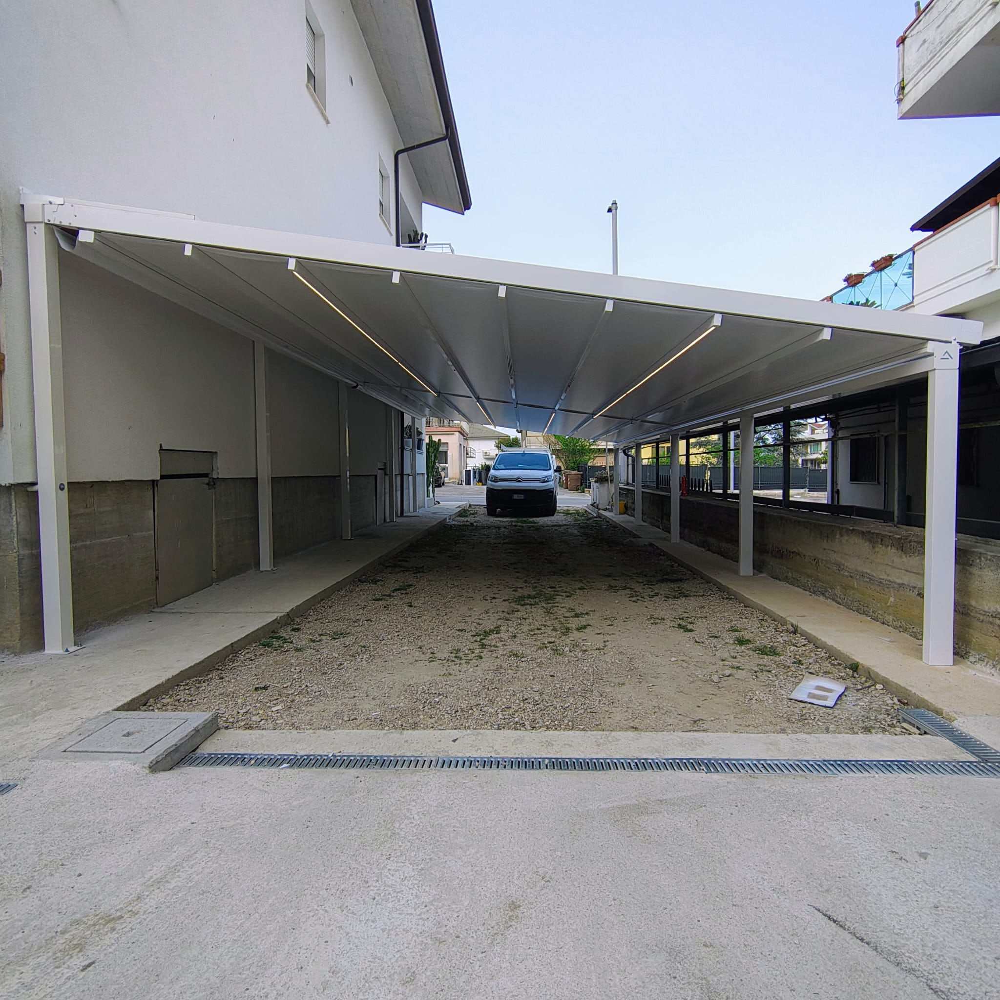 Pergotenda lunga con LED usata come copertura per posti auto
