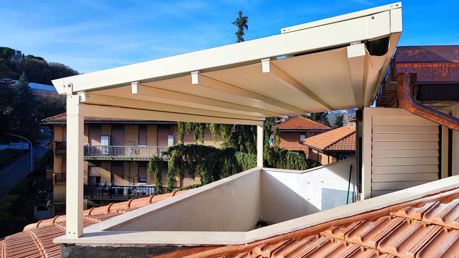 Pergotenda bianca su terrazzo all'ultimo piano con vista sulle colline