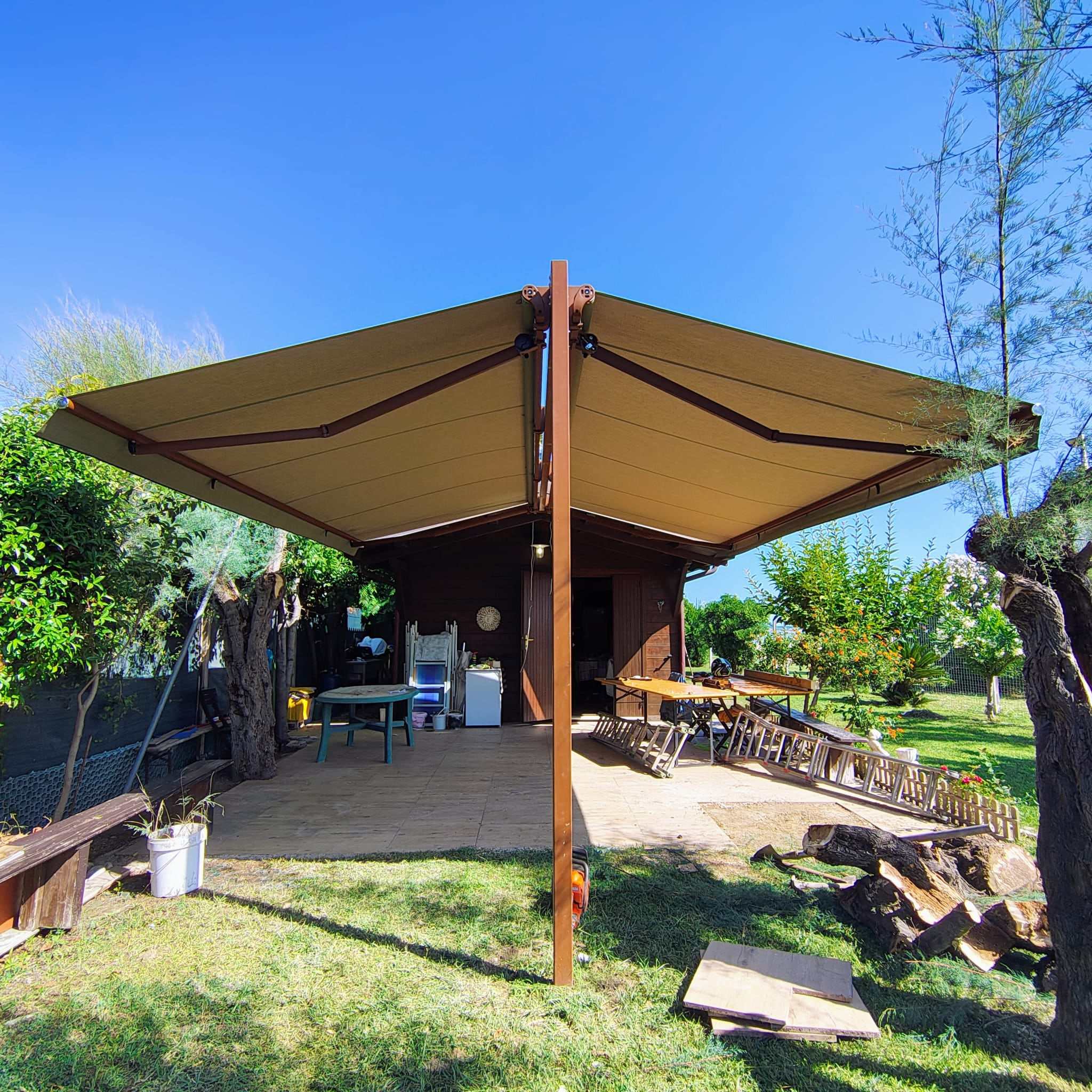 Tenda a doppio braccio su palo centrale in giardino