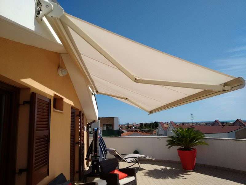 Tenda a bracci aperta su un terrazzo attico