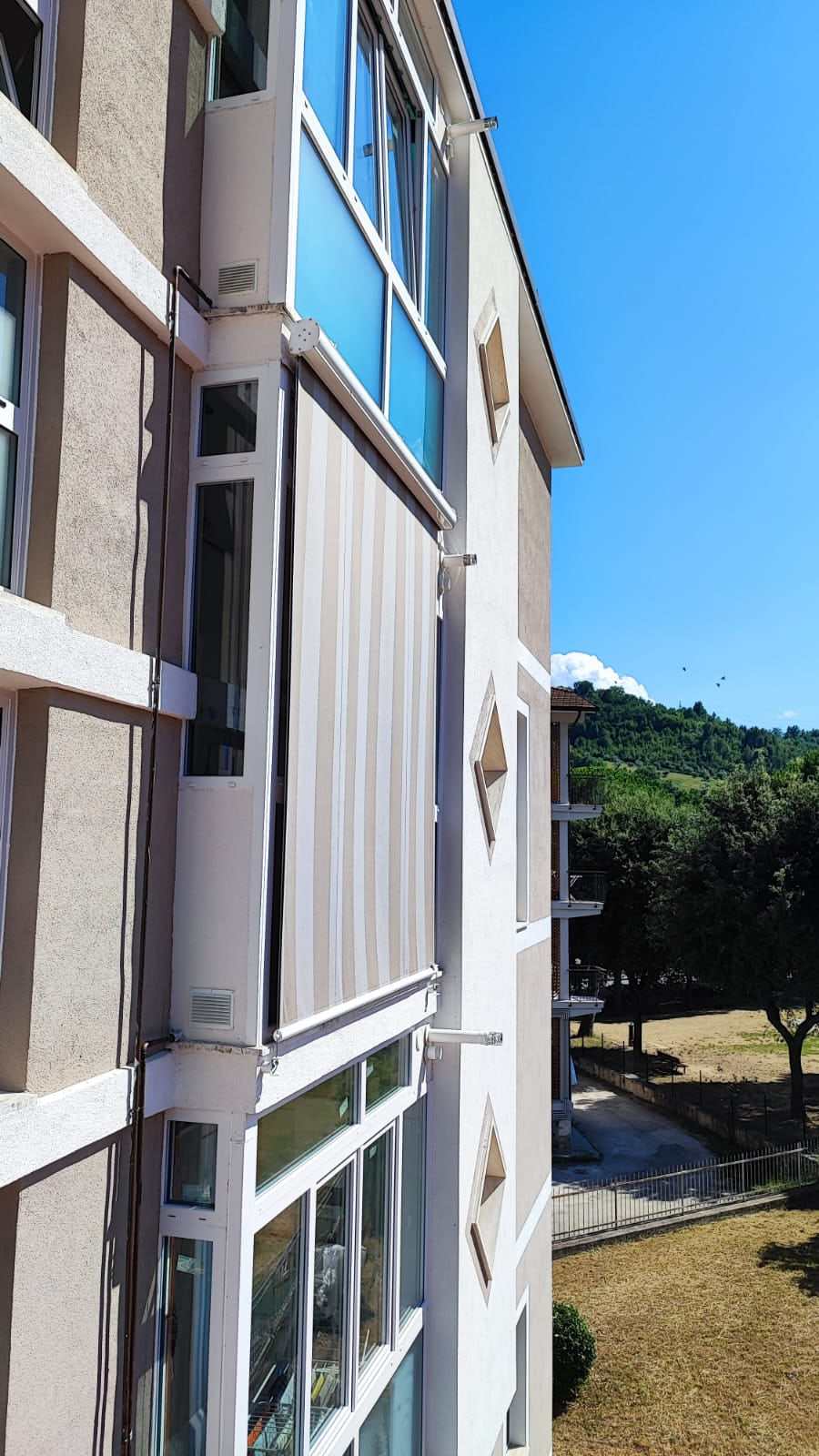 Tenda a caduta verticale a righe su una loggia di palazzina