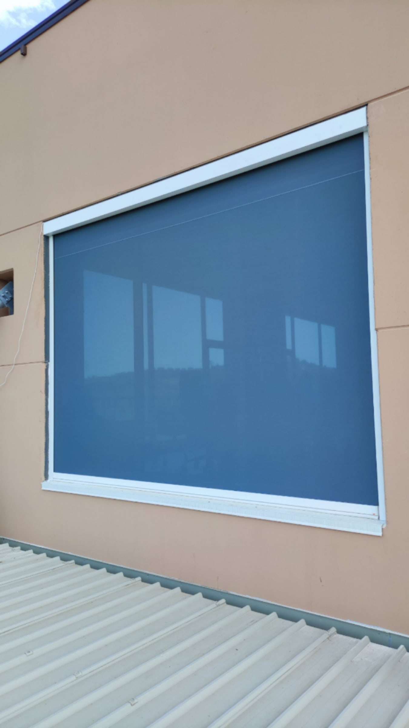 Tenda con guide laterali su una grande finestra di un edificio
