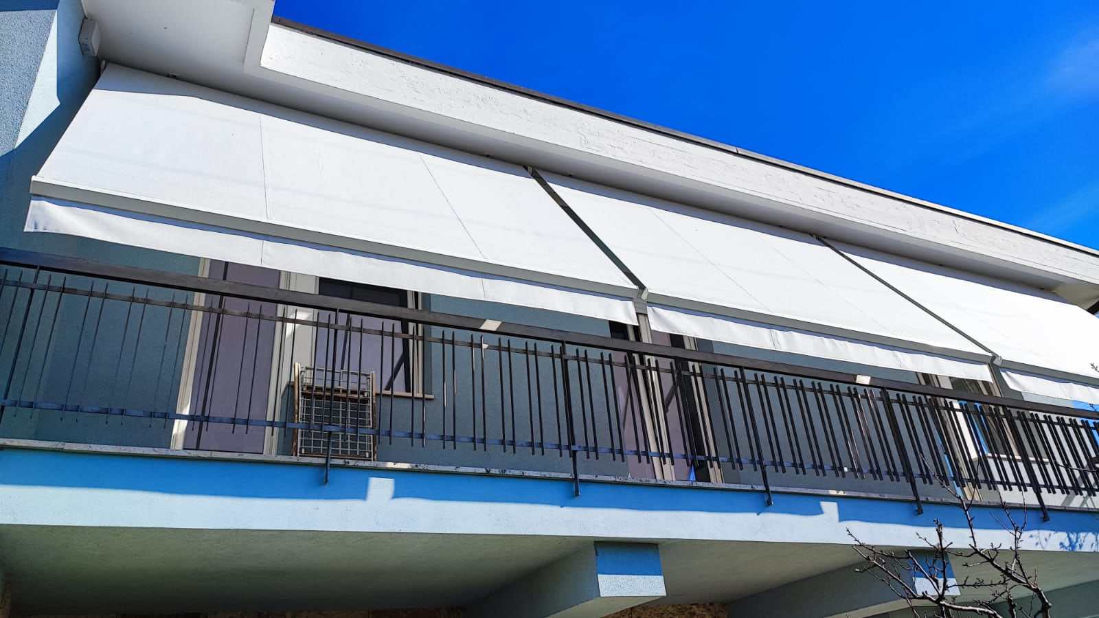 Tende a bracci affiancate su una balconata lunga