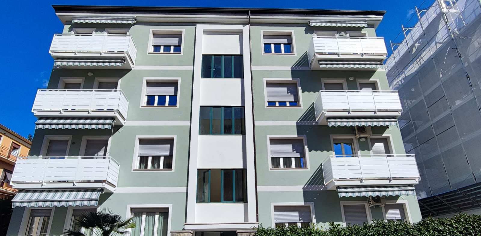 Condominio con tende a caduta con braccetti a righe su tutti i balconi