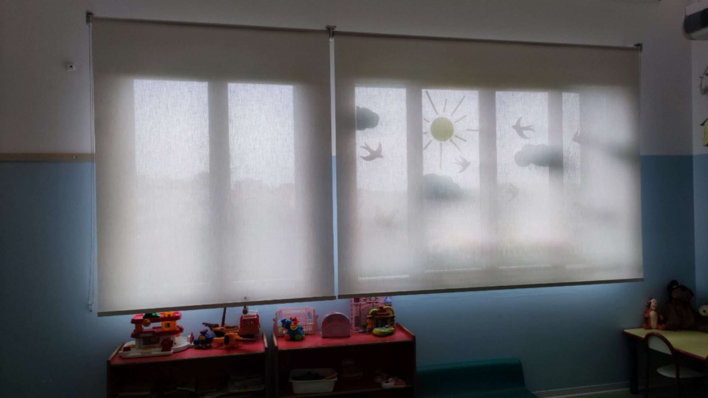 Tende a rullo filtranti chiuse sulle finestre di un'aula scolastica