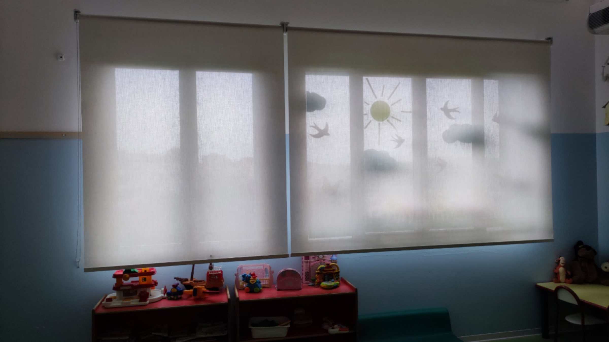 Tende a rullo filtranti chiuse sulle finestre di un'aula scolastica