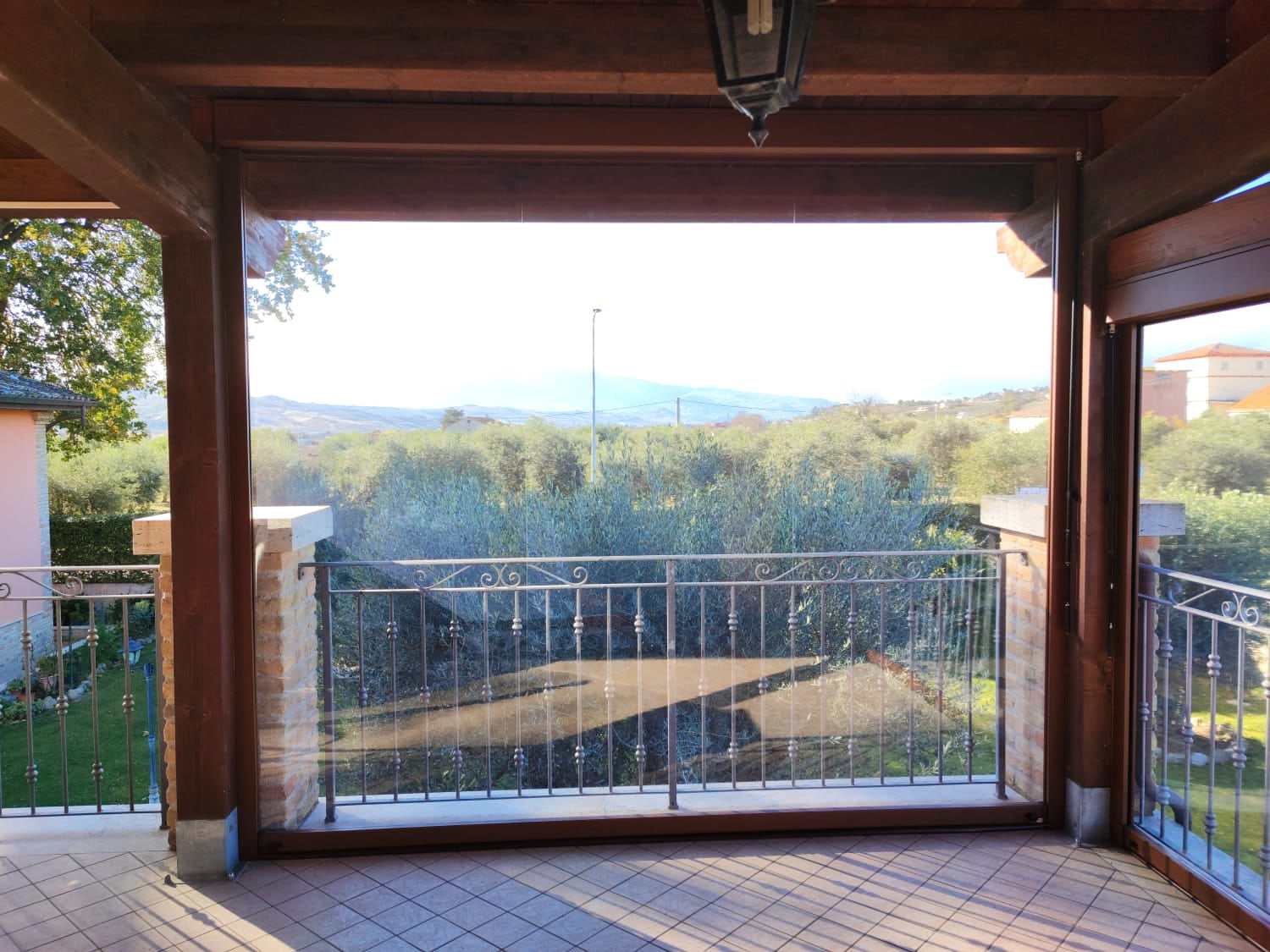 Teli trasparenti antivento abbassati su un portico in legno
