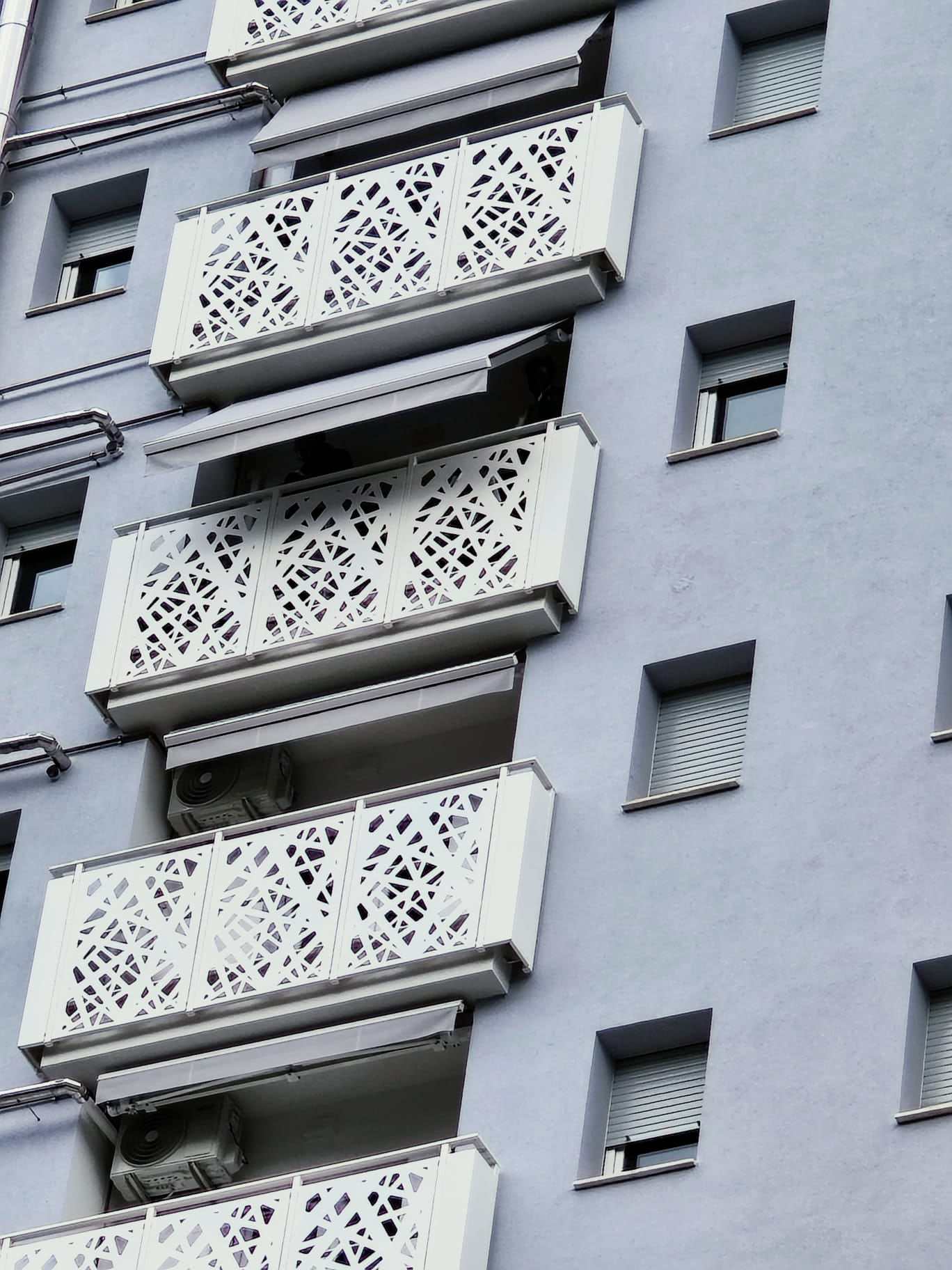 Tende da sole sotto i balconi di un condominio a torre