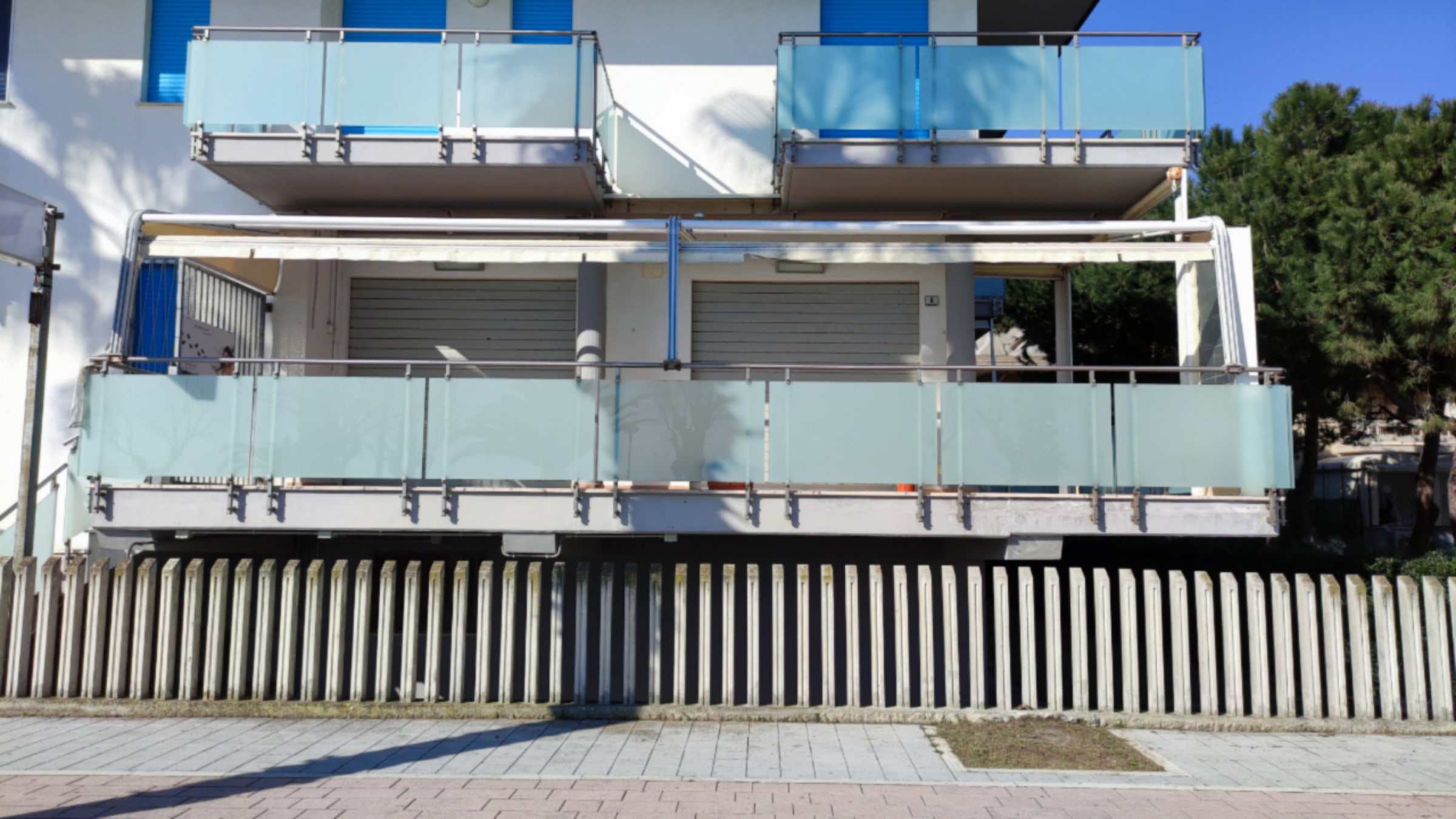 Tende da sole su balconi con parapetti in vetro