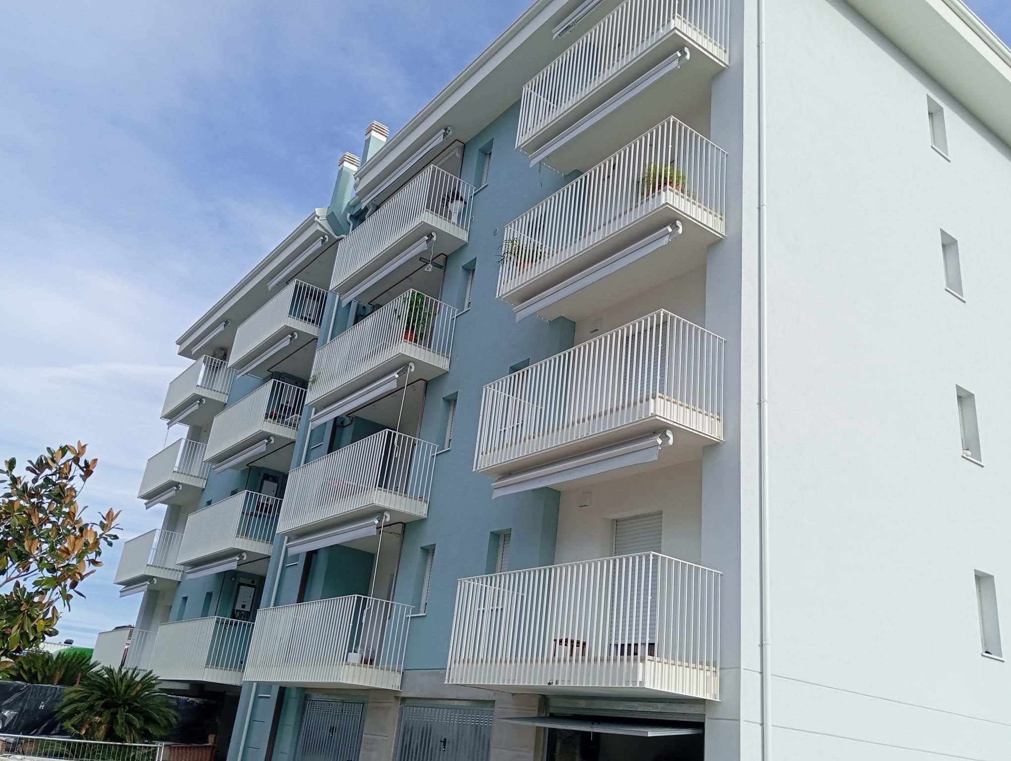 Condominio moderno con tende da sole uguali su tutti i balconi