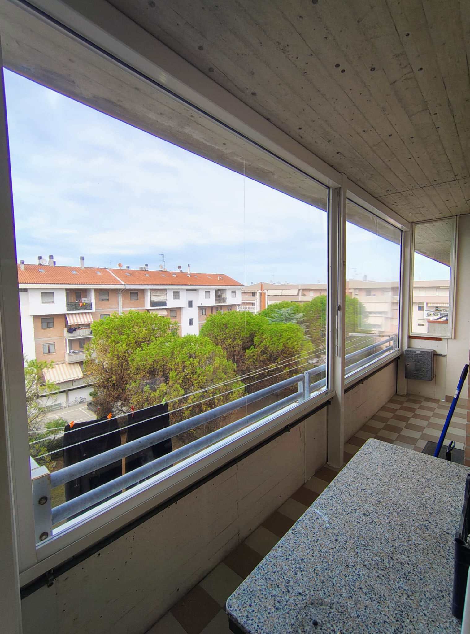 Balcone chiuso da vetrate scorrevoli con vista sui tetti