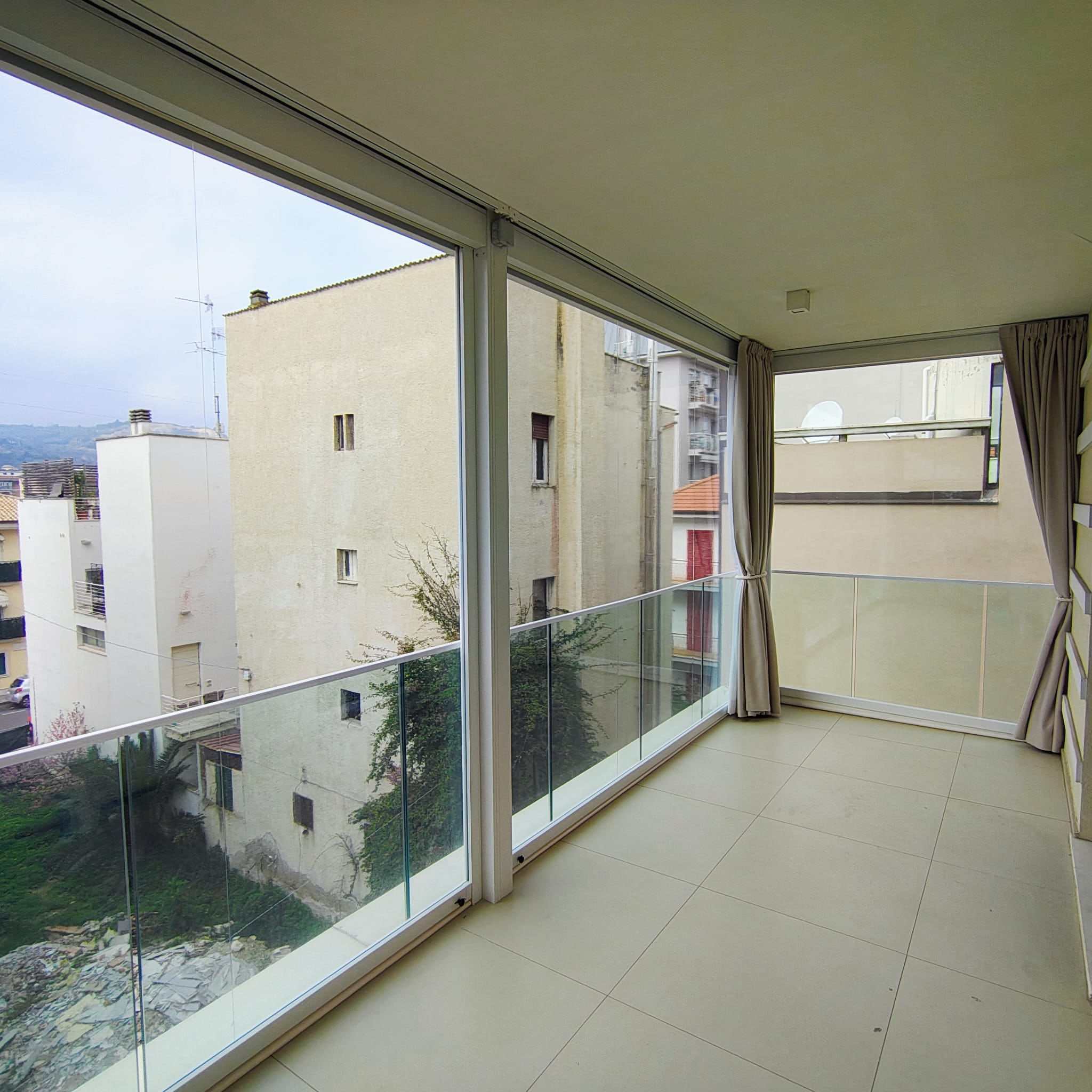 Veranda chiusa da vetrate scorrevoli su balcone