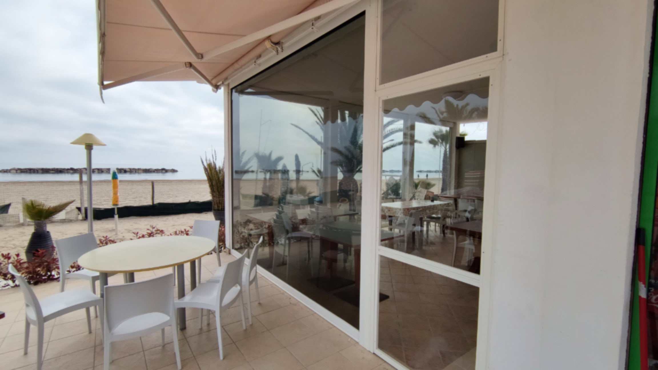 Vetrate e tenda sul fronte spiaggia di uno stabilimento balneare